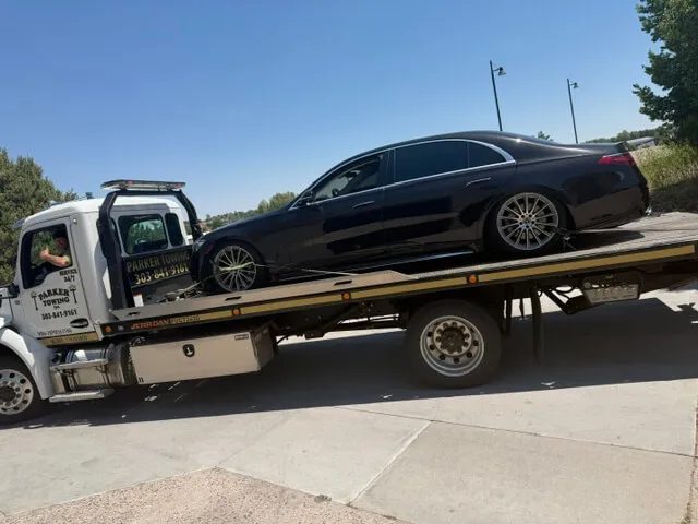 A Parker Towing flatbed with a car loaded and secured
