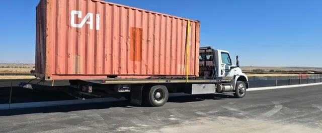 A Parker Towing flatbed transporting a shipping container