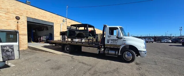 A Parker Towing flatbed recovering a vehicle at a repair yard