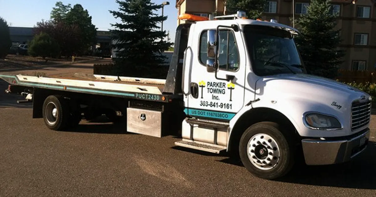 A Parker Towing flatbed tow truck with the company logo and phone number